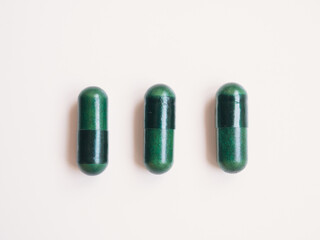 Green pills and white background. Minimal. Medical concept