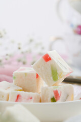 sweet confectionery-marshmallows with candied fruits and black tea in a mug. Tea party at the bright table. close up