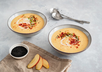 Two bowls of parsnip cream coup on grey background