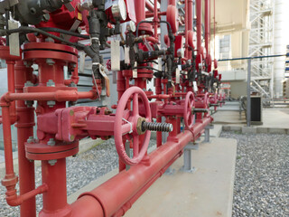 The red hand wheels of metal valve in the factory. Red valve in factory with the fire hose used for fire protection