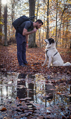 man and his shepherd dog in autumn forest