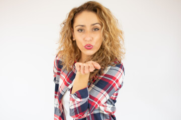 Woman wearing casual shirt. Beautiful woman portrait sending a kiss isolated over studio background.