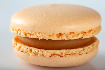 One macaron with cream over white background