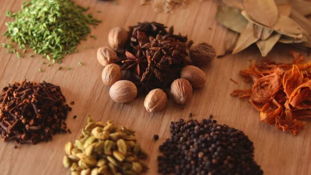 Food and cuisine ingredients,Colourful various herbs and spices for cooking,Indian spices,rotation all indian spices on wooden table, Jaiphal, Star Anise, Chakri fool, Cardamom, Elaichi, 