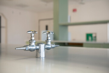 Close up of chrome gas faucets in an empty biotech science lab
