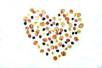 Heart pattern made from minipancakes, grapes and kiwi on a white background. Dessert.