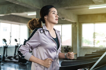 Young asian women running on treadmill in sport club