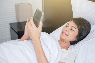 Obraz na płótnie Canvas woman use smartphone bed morning