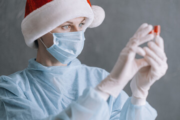 doctor in medical mask and santa on gray background with place for text