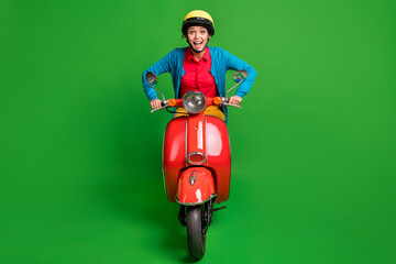 Full size photo of young beautiful happy smiling excited girl wear yellow helmet ride red moped isolated on green color background