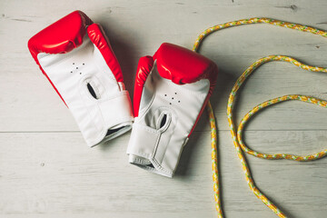 
Boxing gloves and rope on wooden floor
