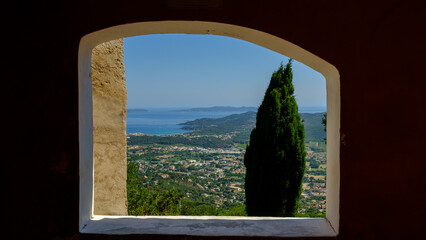 View on a Mediterranean village through a medieval window