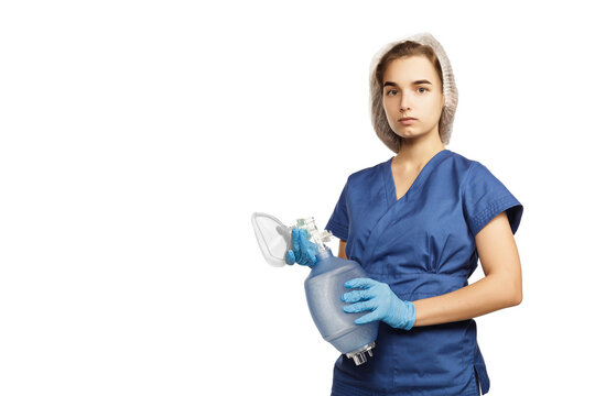 Young beautiful woman doctor in blue surgical gown and gloves holds in hands Am-bu bag for artificial lung ventilation isolated on white background