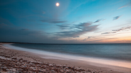 Long exposure blue hour sunset view of the beach of Marmi Ermi, sea, seashore, clouds and full moon