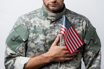 cropped view of patriotic military man in uniform holding american flag isolated on white
