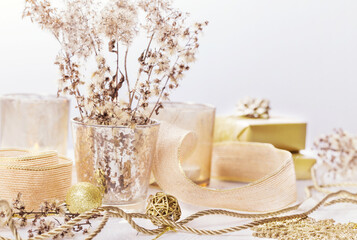 Golden christmas background, spa or beauty concept. Gold candles, gifts, ribbons, dry fluffy plants