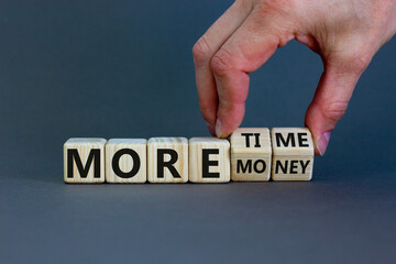More time or more money. Male hand flips wooden cubes and changes the inscription 'more money' to...