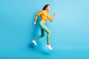 Fototapeta na wymiar Full size profile photo of cool pretty brunette lady jump wear shirt trousers sneakers isolated on turquoise color background