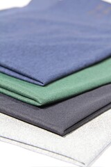 Fototapeta na wymiar Blue green white black sustainable fashion fabric swatches samples folded neatly 