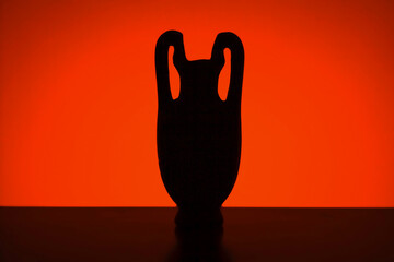 Antique vessel. Silhouette of a vase or amphora against the setting sun.