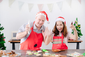 A European girl and her father are wearing gingerbread paint makeup that she finishes for Christmas and New Year