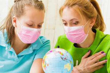 Family in medical masks hugging a globe.