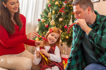 Parents playing with daughter at home for Christmas