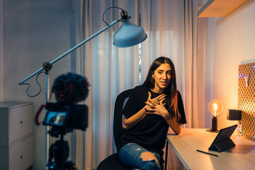 Chica joven morena haciendo vlogs en su cuarto y trabajando en el pc