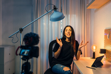 Chica joven morena haciendo vlogs en su cuarto y trabajando en el pc