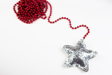 Christmas red decoration together with a shiny star in sequins isolated on a white background.