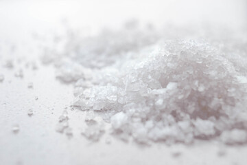 Heap of white sea salt on the marble table. Side view.
