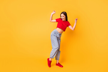 Full length photo of dancing lady at students party wear red crop top jeans shoes isolated yellow color background