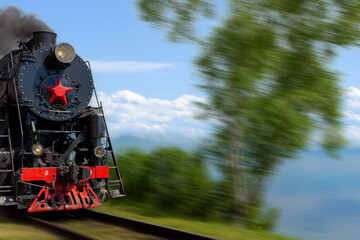 Historical steam train on the defocused background of lake Baikal on the Circum-Baikal railway. Retro-style tourist steam locomotive