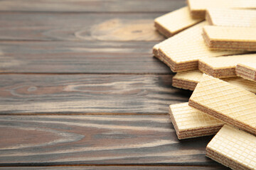 Sweet wafers on brown wooden background, top view.