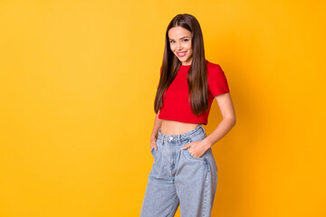 Attractive lady good mood wear casual red crop top jeans standing over yellow vivid color background