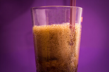 fizzy and carbonated soft drink called cola on purple background
