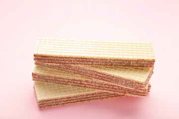 Tasty wafer sticks on pink background. Sweet food