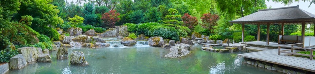 Beautiful Japanese garden with pond and hut, in panorama format - obrazy, fototapety, plakaty