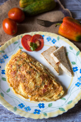 Close up of  fried eggs omelette in a plate along with bread and condiments. 