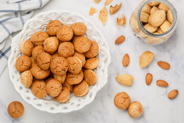 Amaretti-traditional Italian almond cookies in a white plate on a marble top view background. Amarettini biscuits. Selective focus