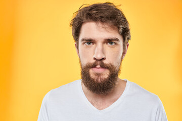 Obraz premium emotional bearded man in t-shirt cropped view yellow background studio