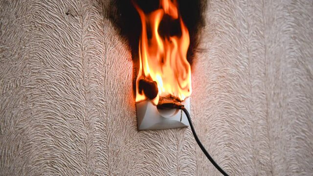 The socket and plug of the electric wire light up. Short circuit in the circuit, causing the electrical wire to burn out. Property insurance concept.