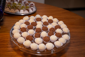 Foto feita em um evento social. Vasilha de vidro cheia de doces para festa.