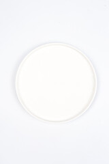 round white ceramic plate on a white background. Look from above