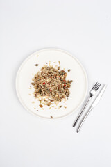 wild rice with spices on a white plate on a light background. Look from above