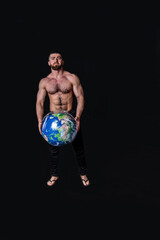 handsome physically well-developed man with a mock planet earth in his hands