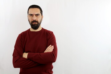 Young bearded man on isolated white background with serious face and crossed arms, angry man