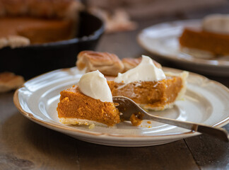 Homemade pumpkin pie baked in cast iron pan, on wooden background