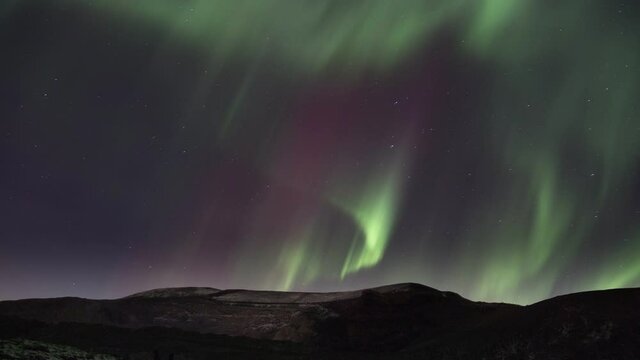 Seamless Loop of Northern Lights Cascade Over Mountains on Starry Sky