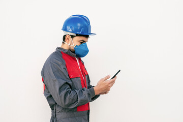Bearded worker man with face mask looking smart phone